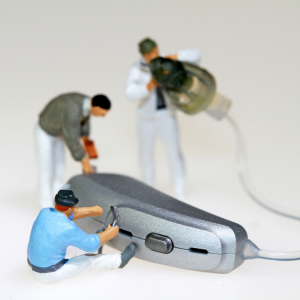 tiny workers repairing a hearing aid