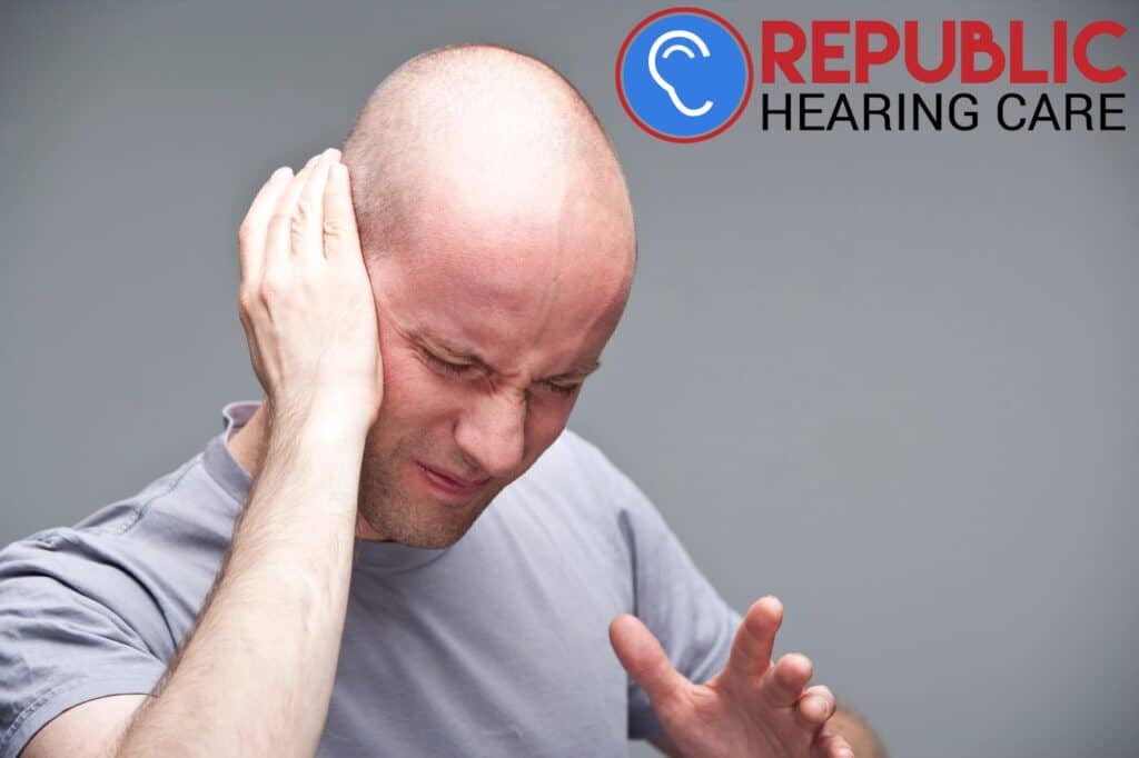 man holding his ear in pain