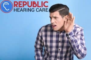 man holding his hand to his ear